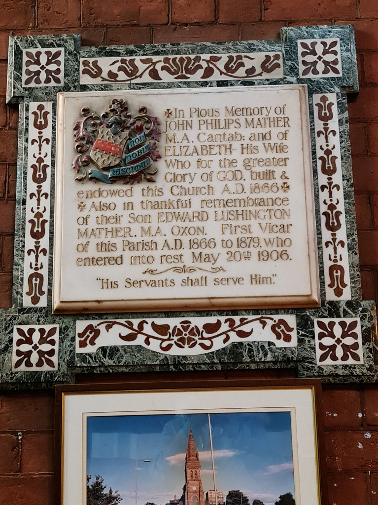 Marble plaque which reads:  "In pious memory of John Philips Mather MA Cantab and of Elizabeth his wife who for the greater Glory of GOD built and endowed this Church 1866.  Also in thankful remembrance of their son Edward Lushington Mather MA Oxon. First Vicar of this Parish AD 11866 to 1879 who entered into rest May 20th 1906.  'His Servants shall serve Him.'